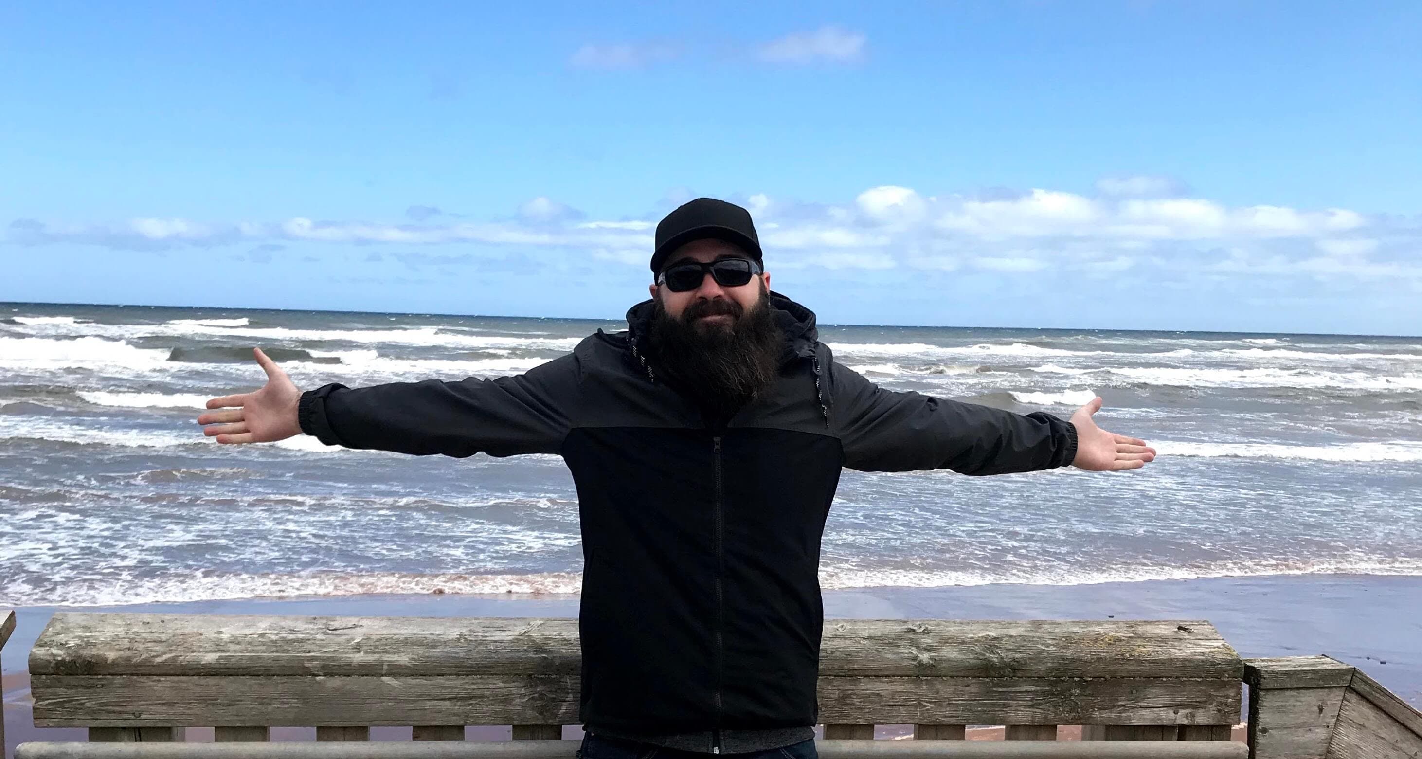 David with his arms spread wide standing infront of the Atlantic Ocean